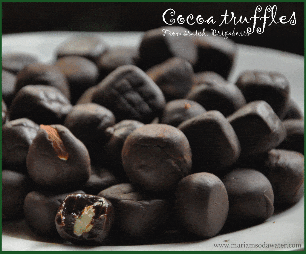 Cocoa condensed milk truffles served in a plate with half eaten truffle revealing almond in between.