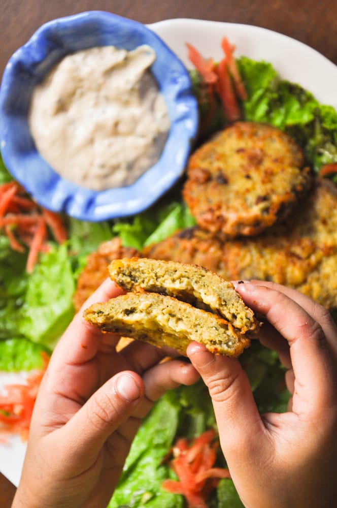 Kheema cutlets served in a plate with salad leaves and chutney on the side.
