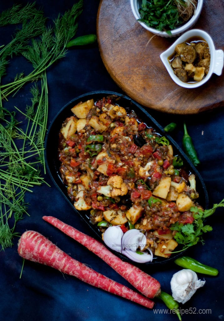 Mix vegetable curry Pakistani Style served in a plate with raw veggies on the side.