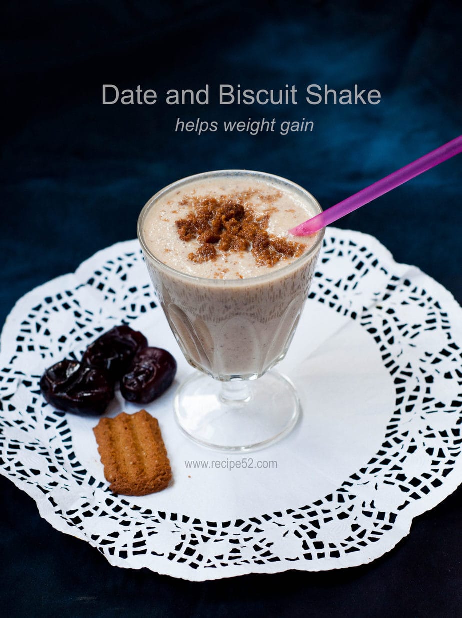 Date milk shake served in glass with biscuit and dates on the side.
