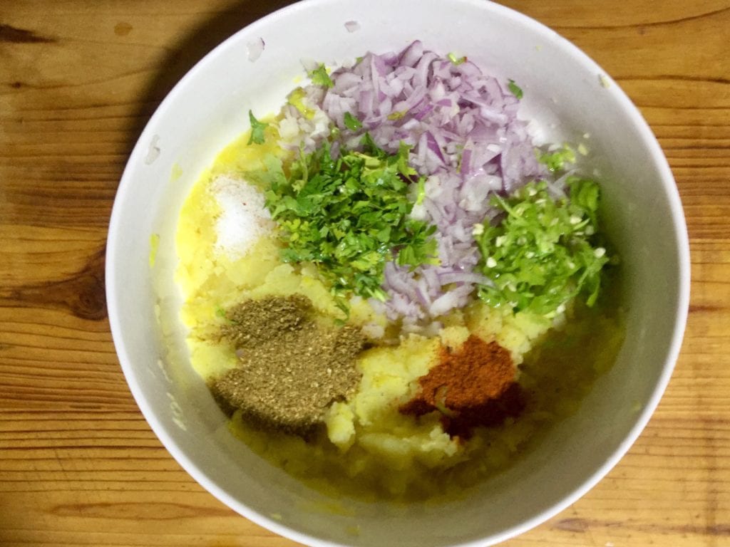 Season boiled potato for aloo ki roti.