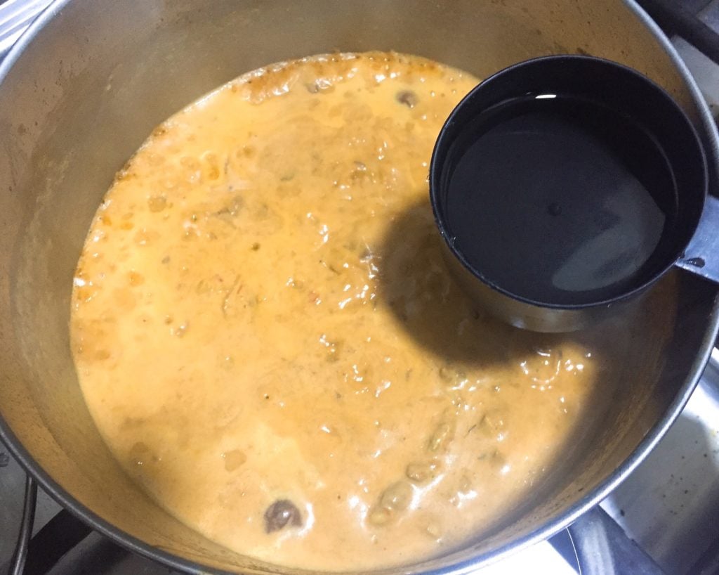 Add water to khao soi curry.