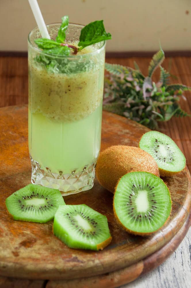 Kiwi Drink served in a glass with straw and mint leaves.