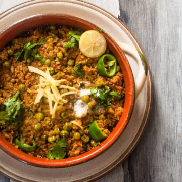 Keema Matar served in a pot with garnish.