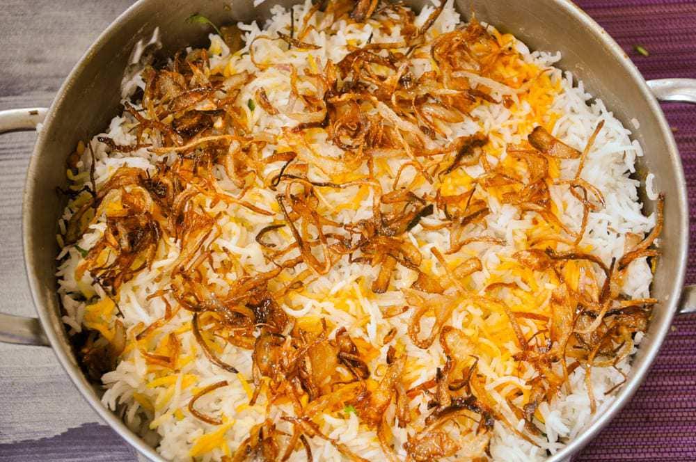 Add fried onions and yellow colour to the rice.