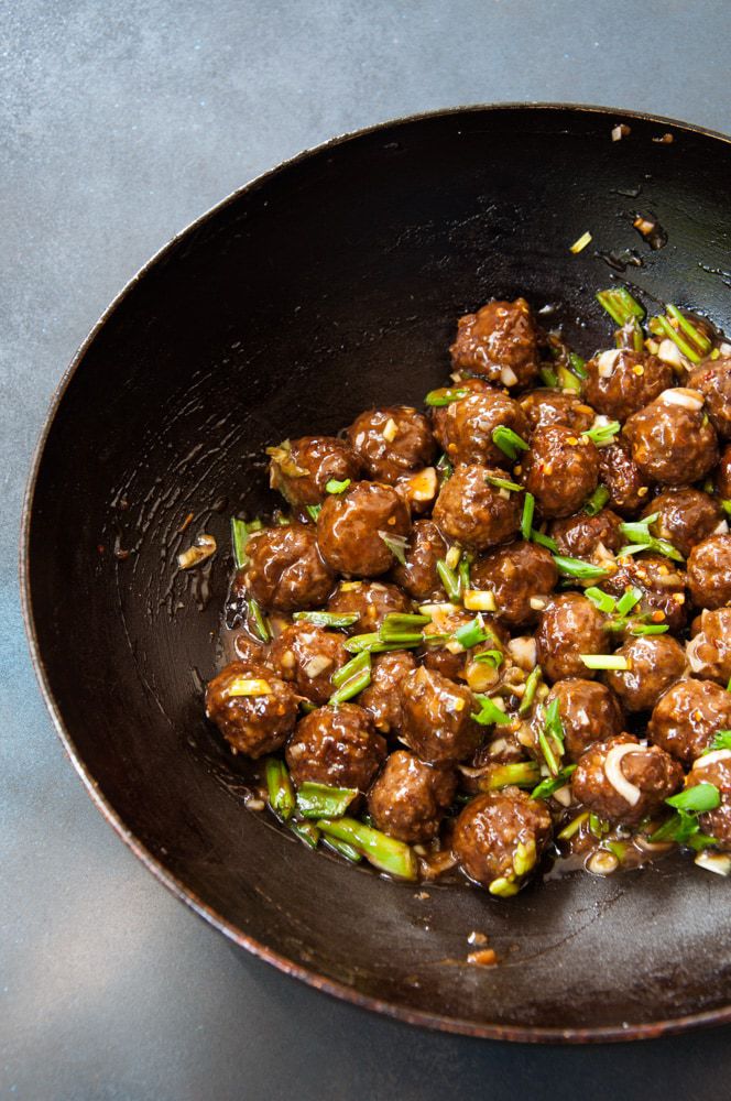 Mongolian meatballs in a wok over grey background.