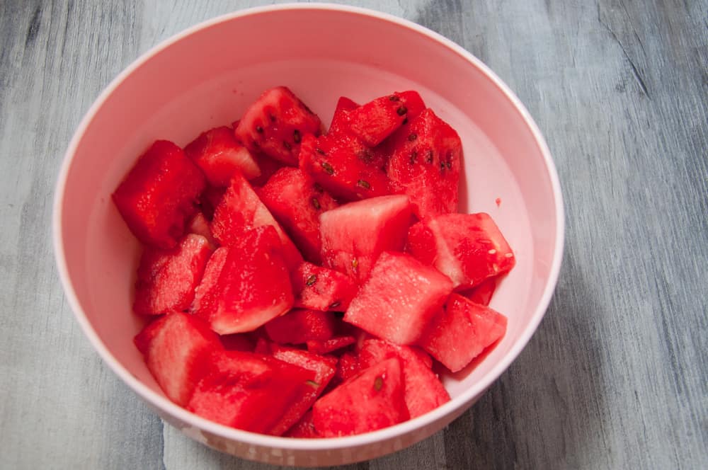 Watermelon chunks in a large pink bowl.