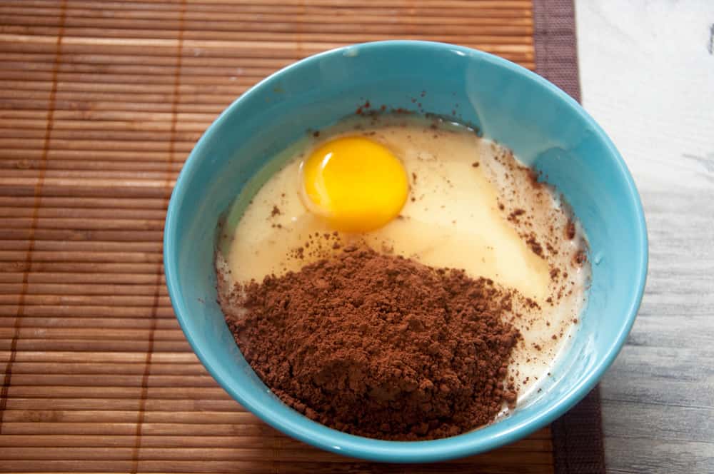Egg, cocoa powder and condensed in a bowl.