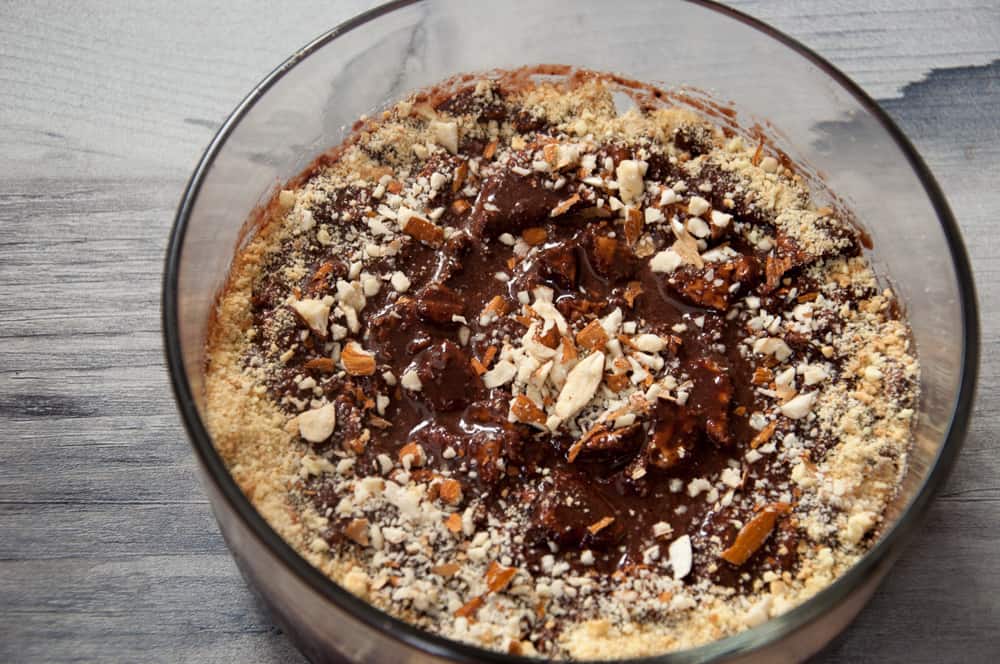 Chocolate biscuit pudding in a bowl  garnished with nuts and crushed biscuits.