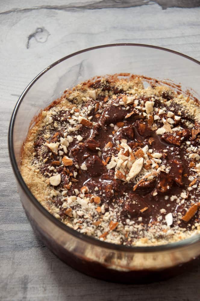 Chocolate biscuit pudding served in bowl with nuts garnish.