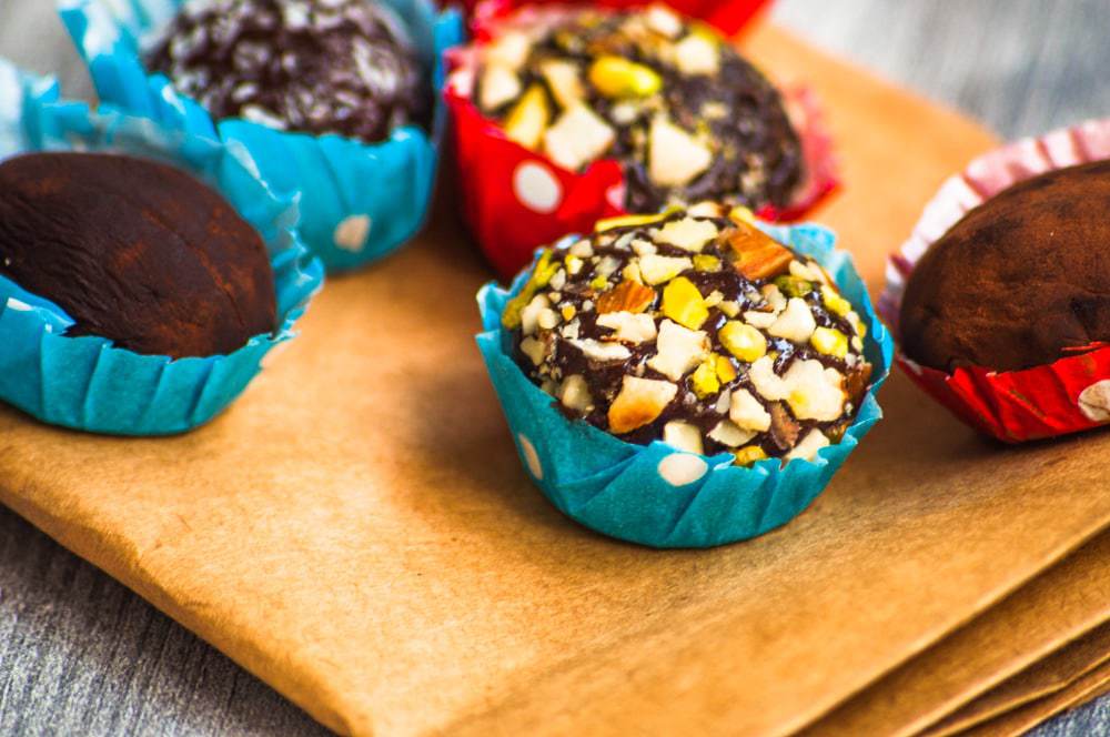 Brigadeiro truffles with pistachio, cocoa and coconut variation served in red and blue dotted bonbon cups.