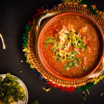 Warm Nihari served in a clay bowl with garnish on top.