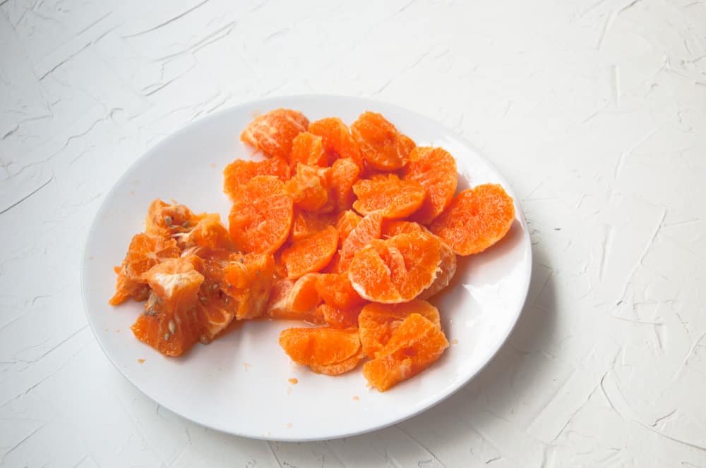 Sliced and pitted oranges in a plate.