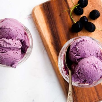 Cherry ice cream with fresh cherries on the side.