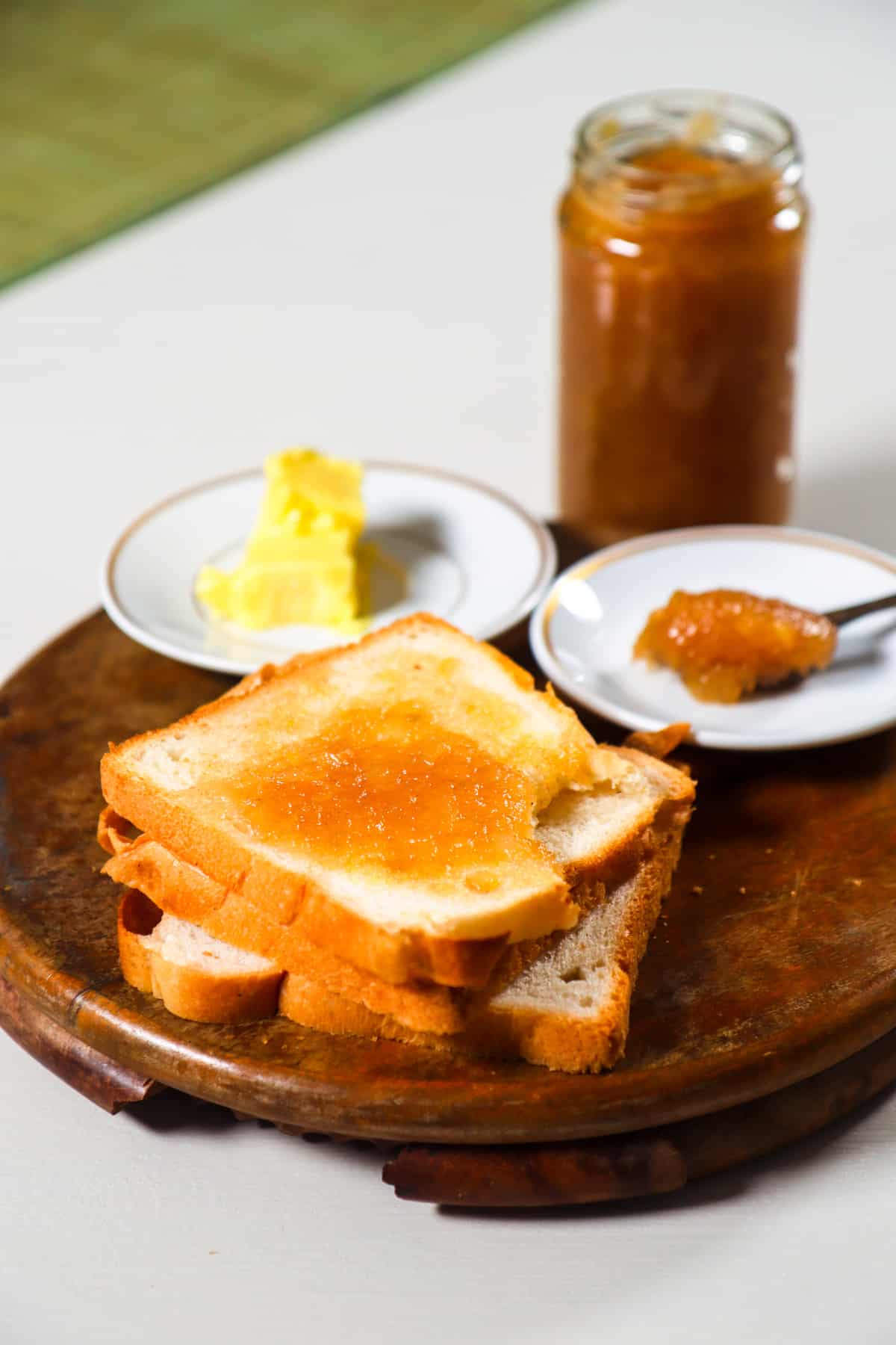 pear jam spread on a toast with jar of jam in the background.