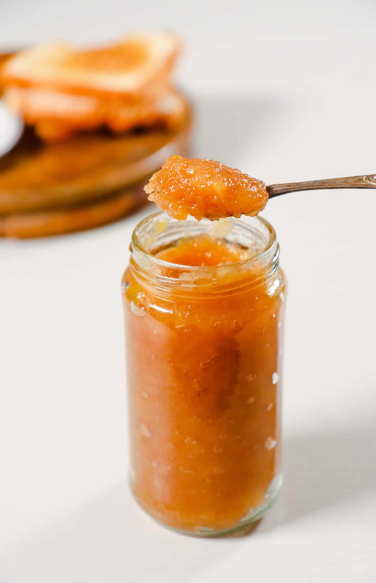 Spoon full of jam on the jar of Pear ginger jam.