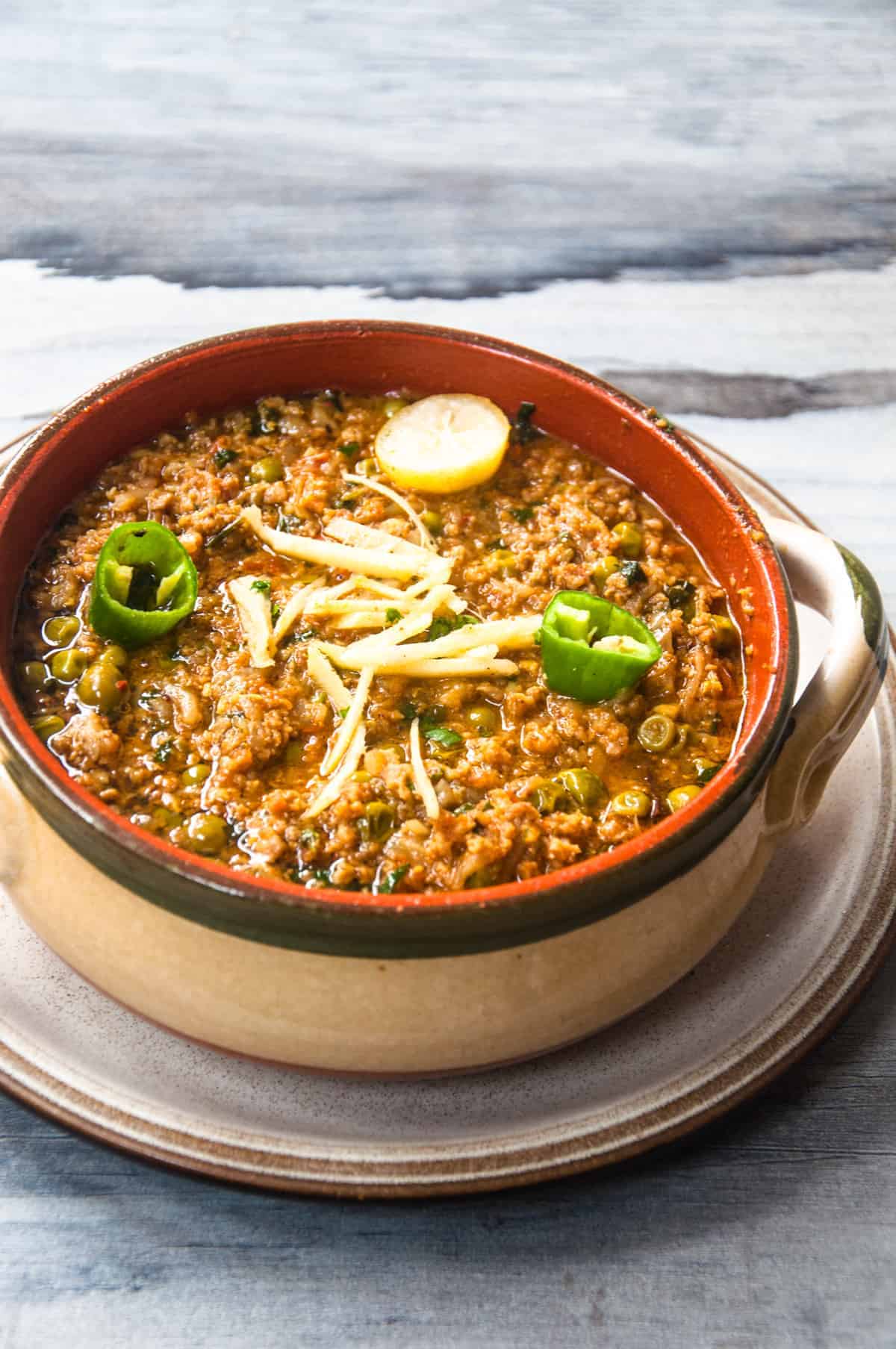 Pakistani keema matar served in a clay bowl. 