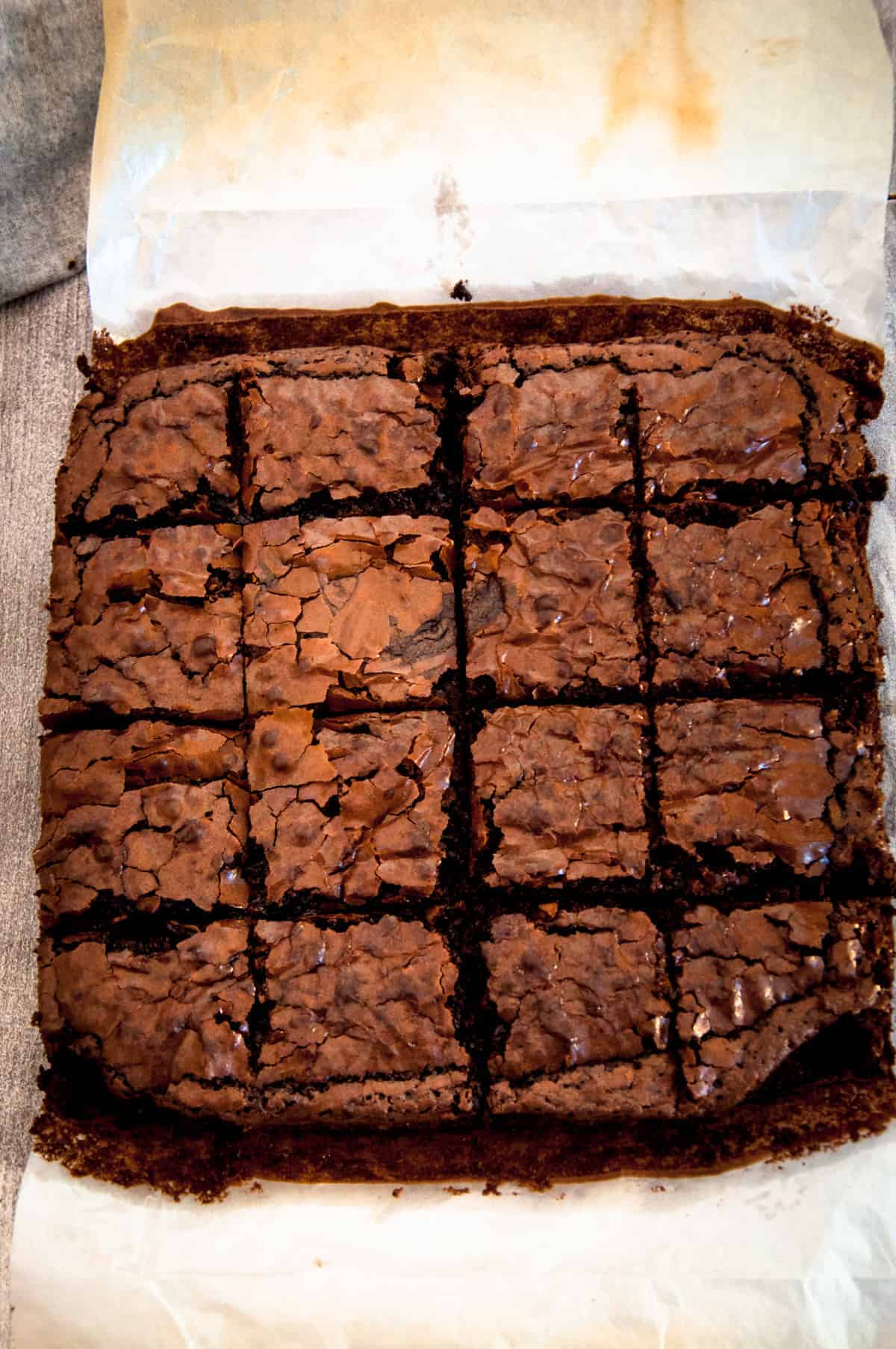 Brownie squares on the butter paper.