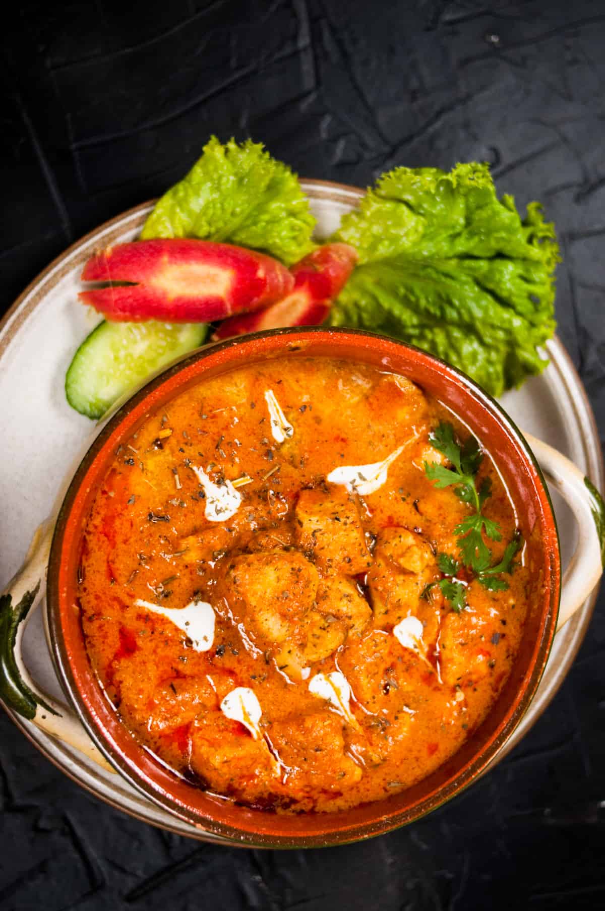 A close up shot of chicken handi on the black background.