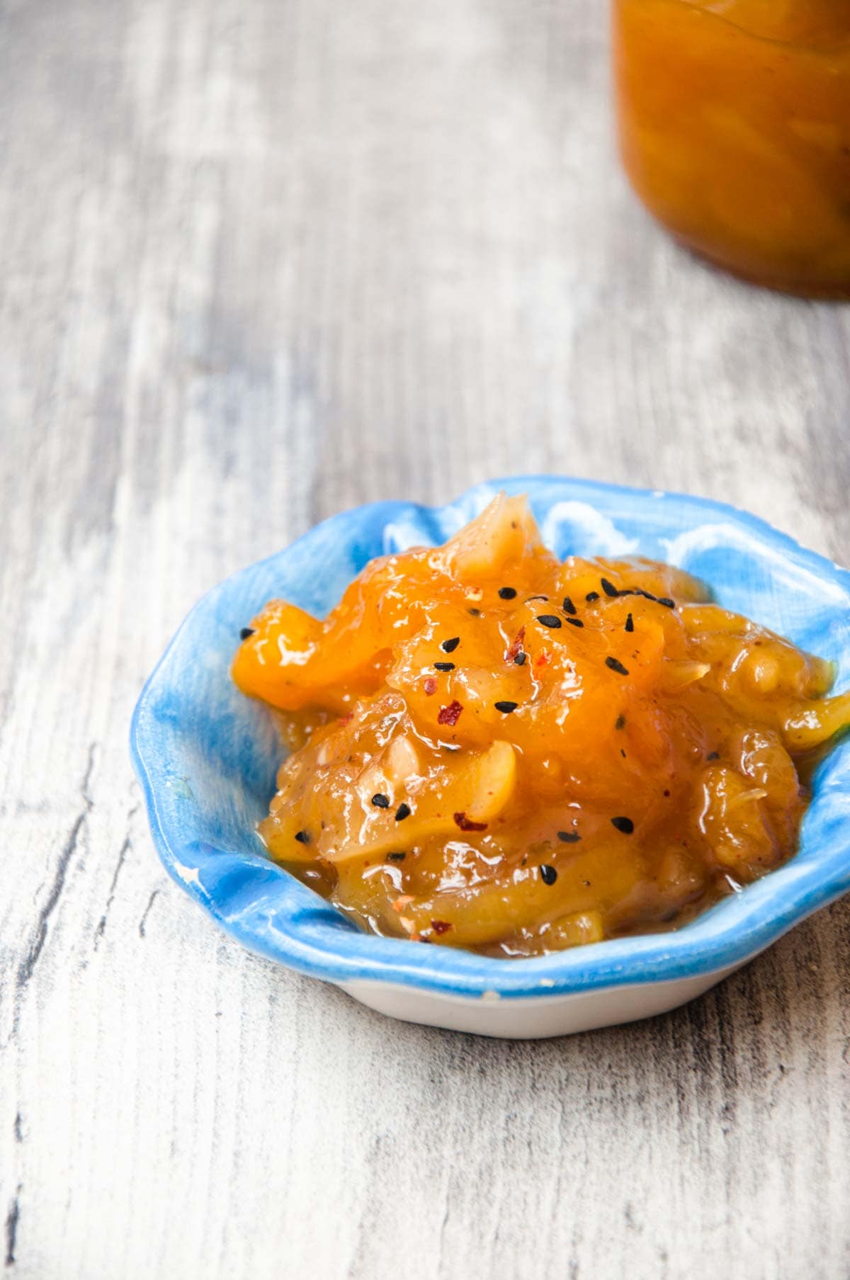 Indian mango chutney served in a sauce bowl over grey background.