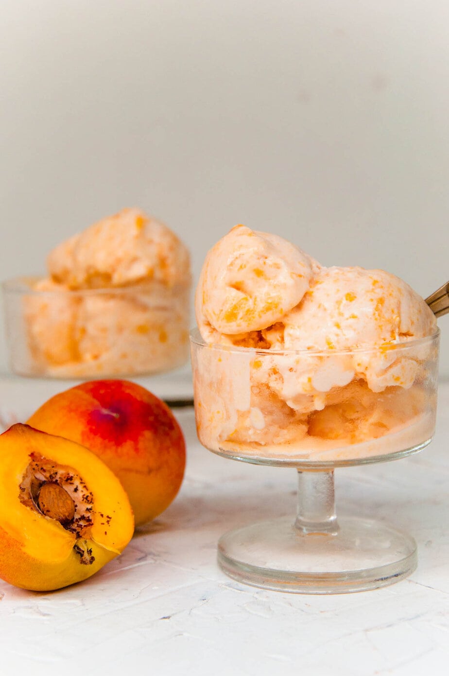 Peach ice cream scoops in ice cream cups.