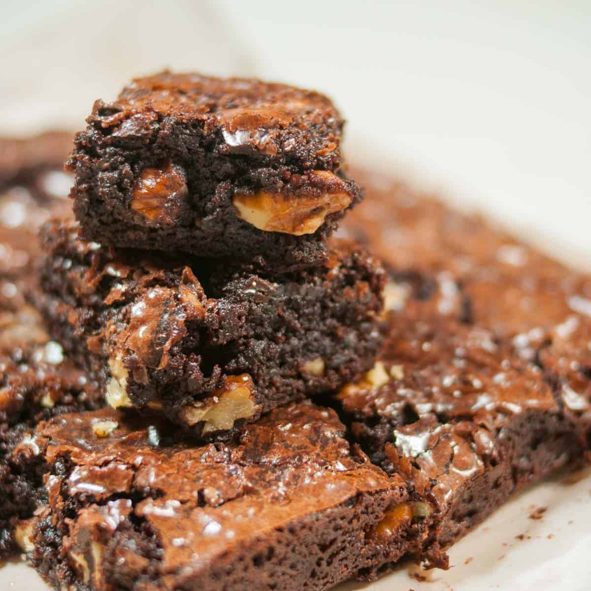 A close shot of side view of Chocolate brownie showing fudgy center and walnuts.