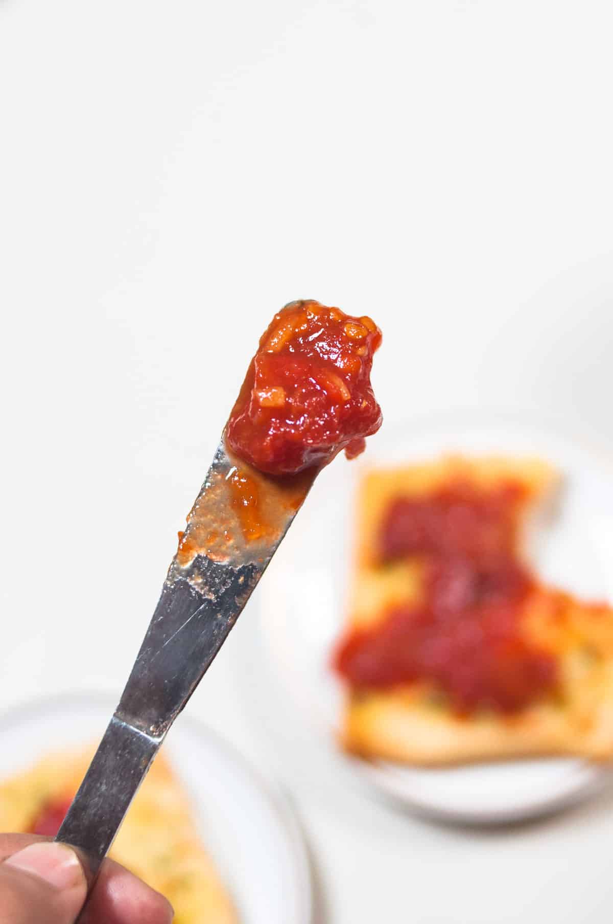 Tomato jam on a bread knife.