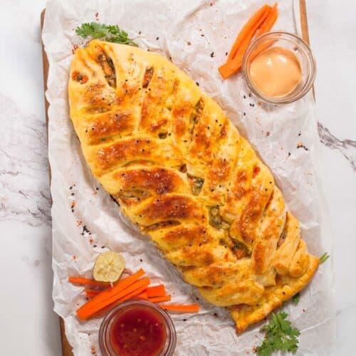 baked chicken bread on butter paper with vegetables and dip