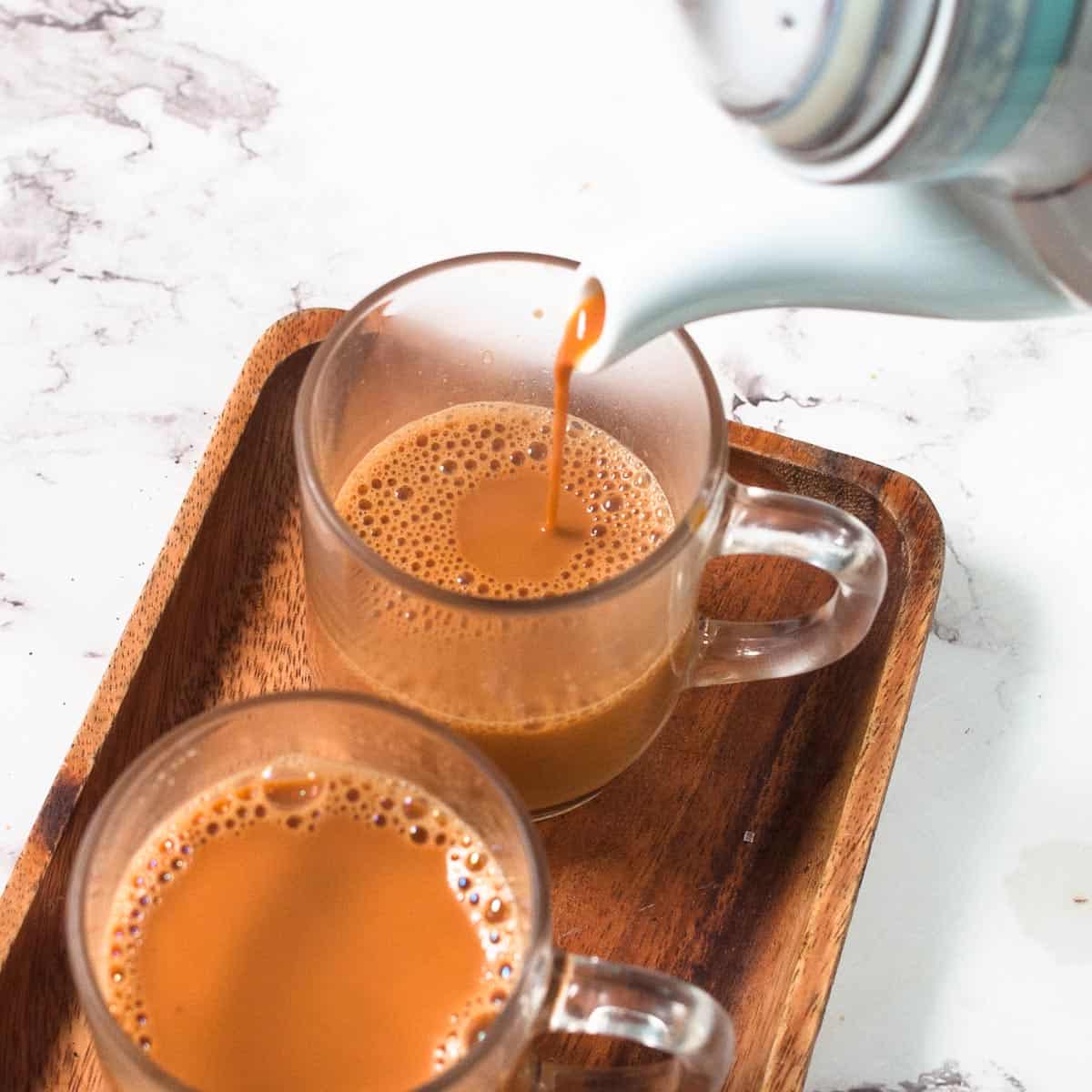 Tea pouring from the tea pot into a cup.