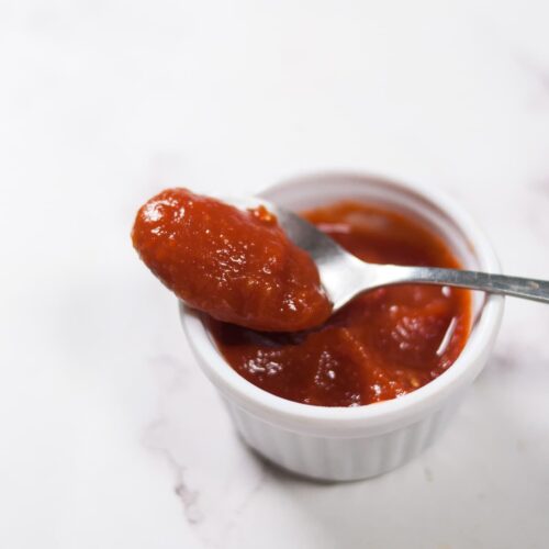 Tomato ketchup in a spoon.