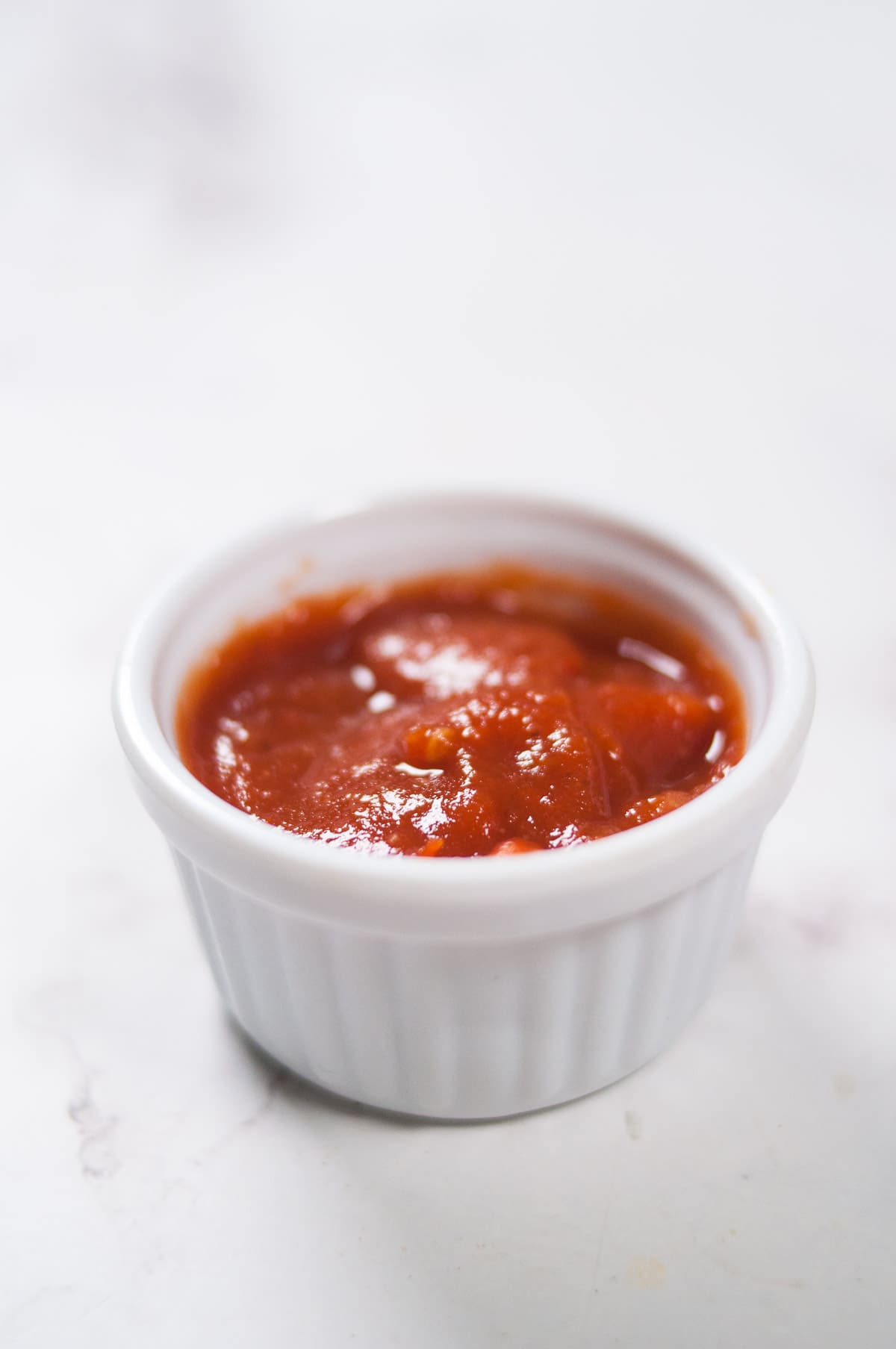 A close up shot of ketchup in a container.