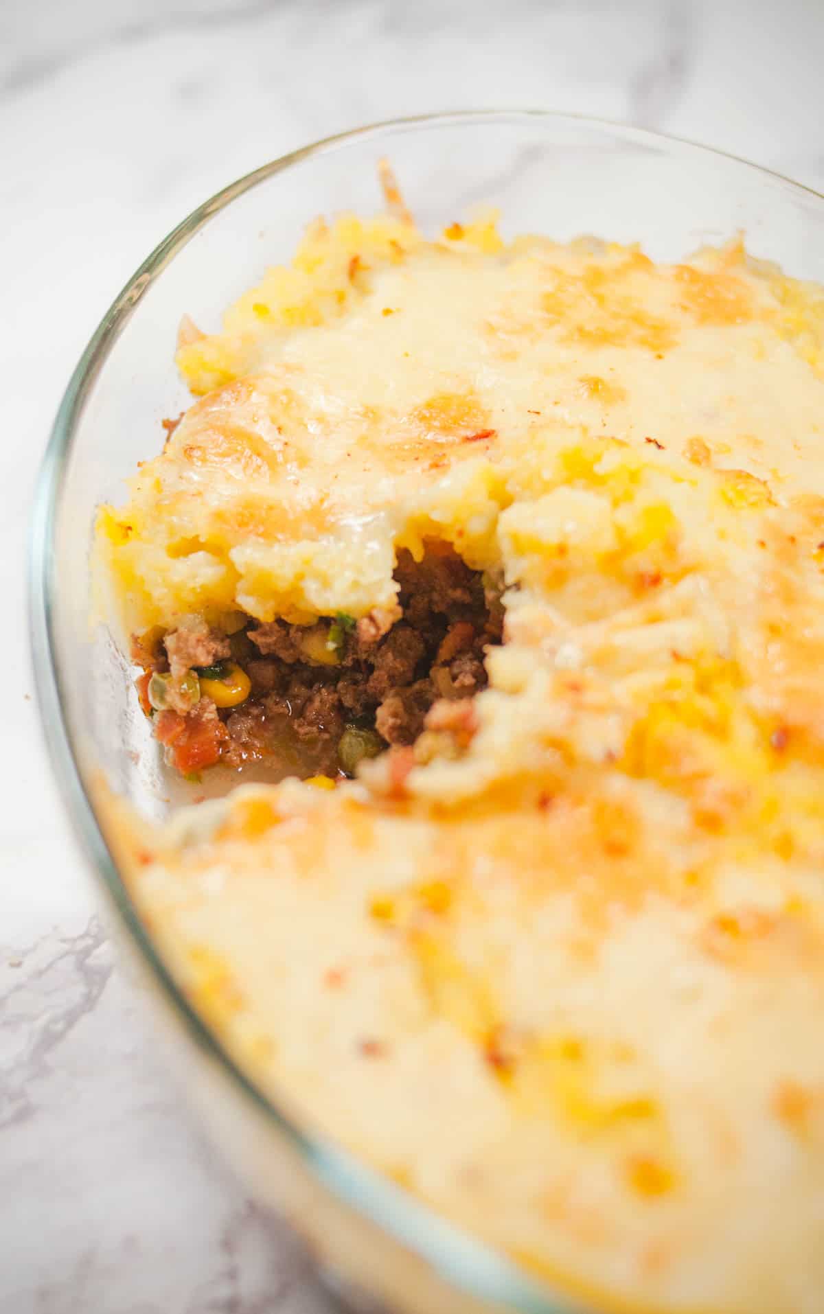 A close up showing filling of baked spicy shepherds pie.