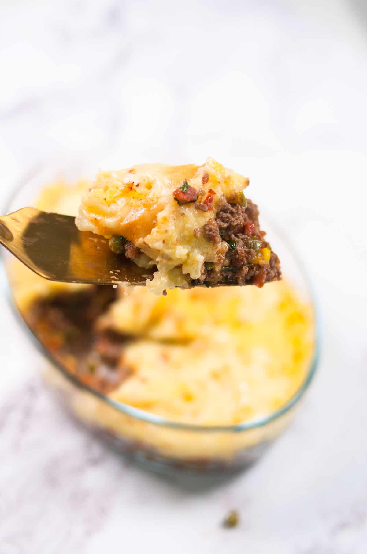 A small portion of shepherd's pie scooped out with a spoon.