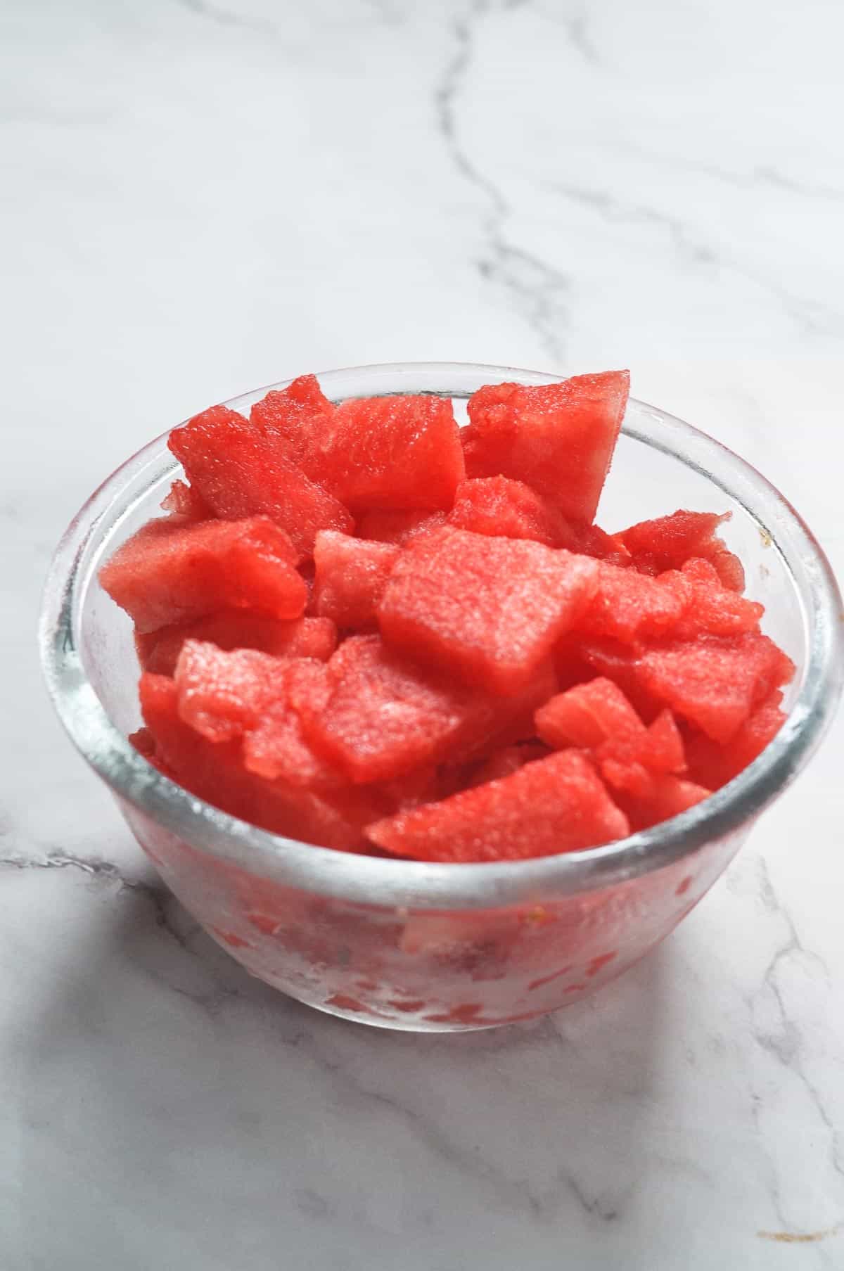 frozen watermelon cubes in a glass bowl.