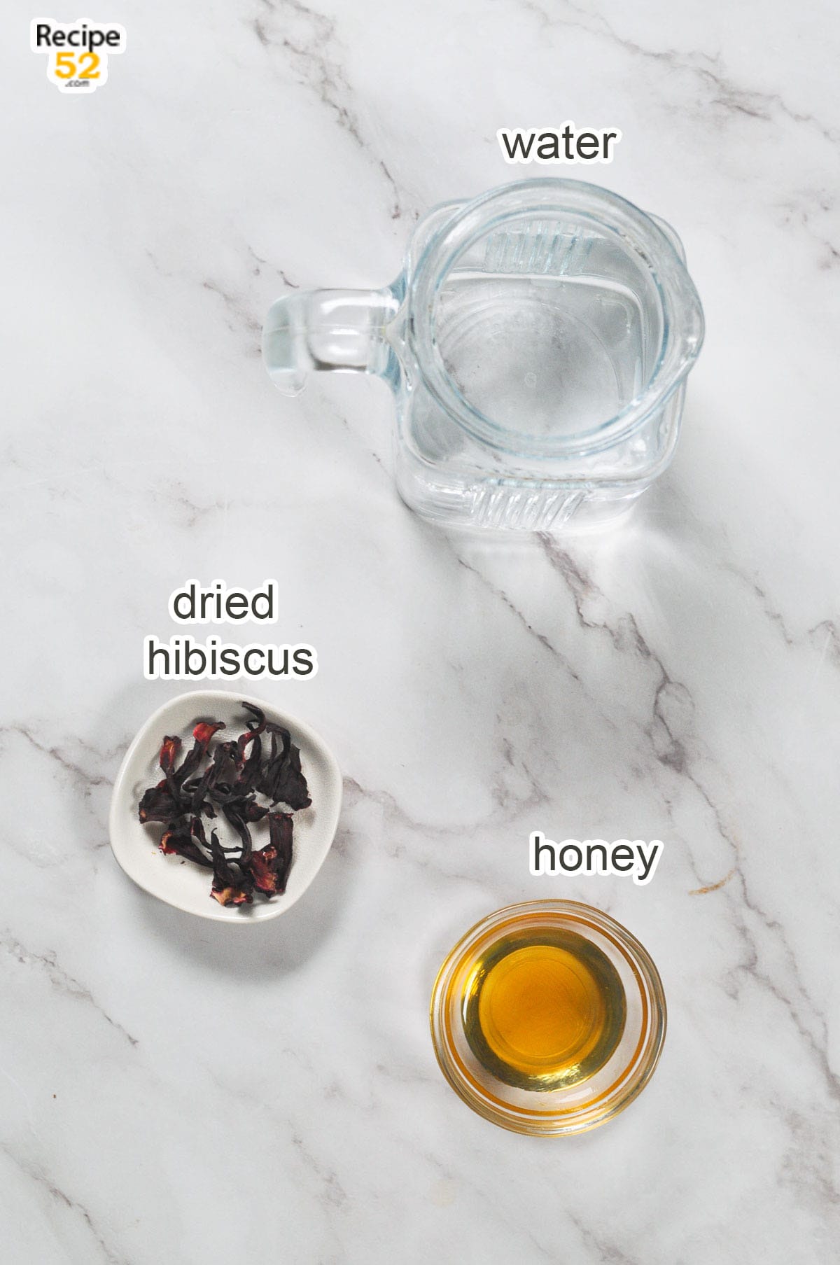 Water in a jug, dried hibiscus, and honey in a small container.