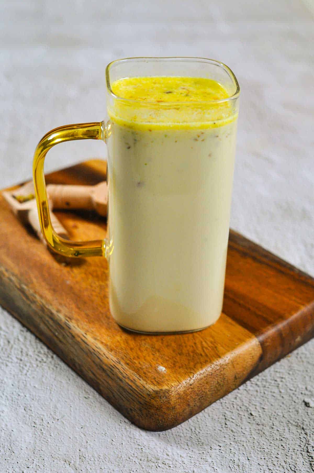 Transparent glass of milk with a golden handle. - 4