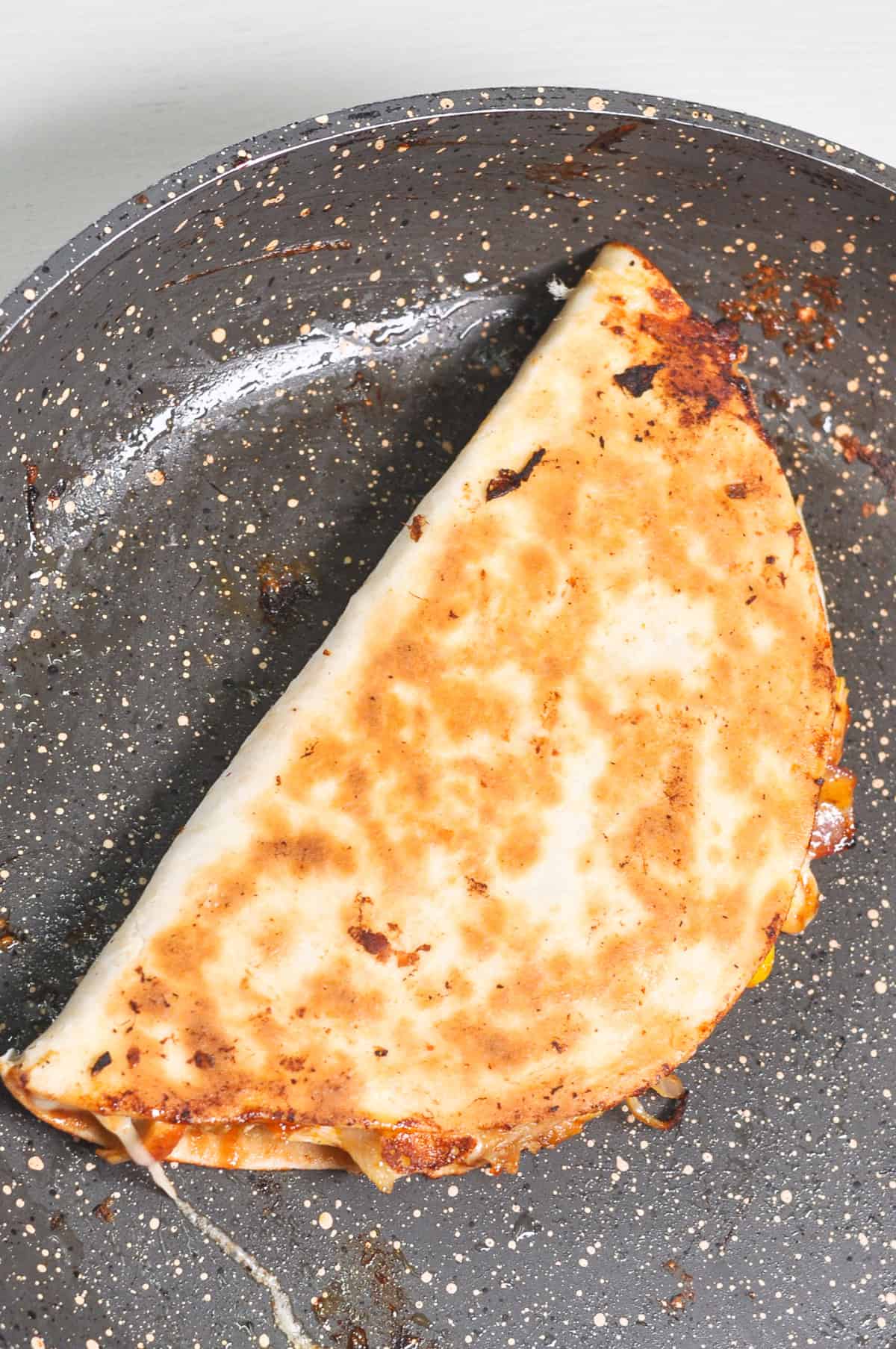 Toasted quesadilla in a pan.
