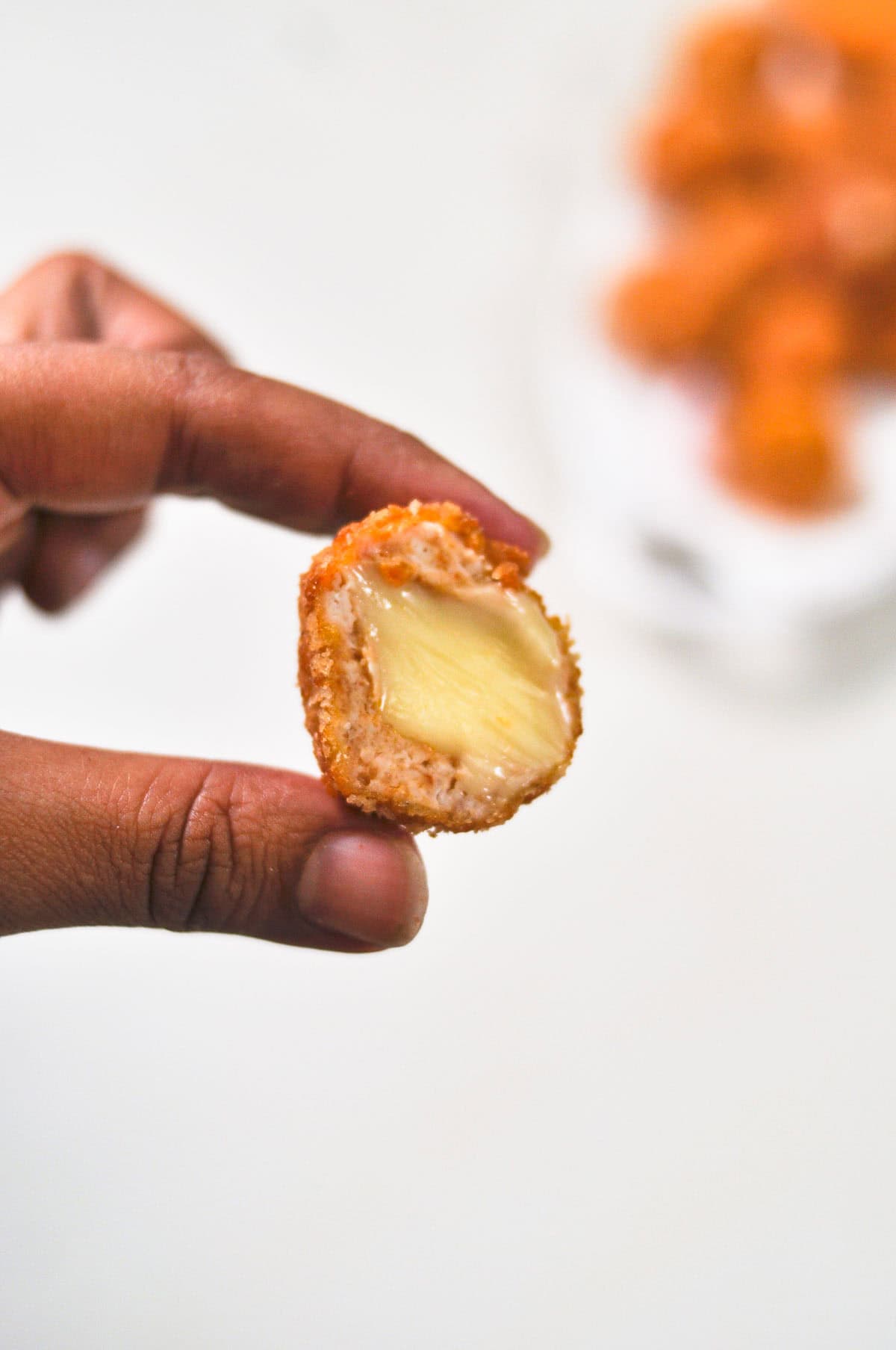 A close-up shot of a halved cheesy nugget.