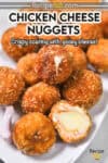 The image features a close-up shot of several golden-brown, breaded chicken nuggets (shaped like balls) piled onto a white plate.